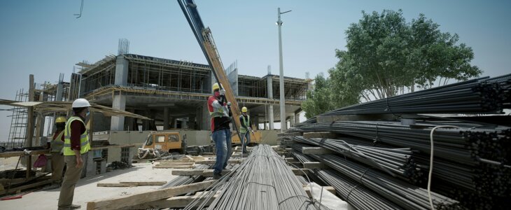 Workers lifting metal bars at a construction site