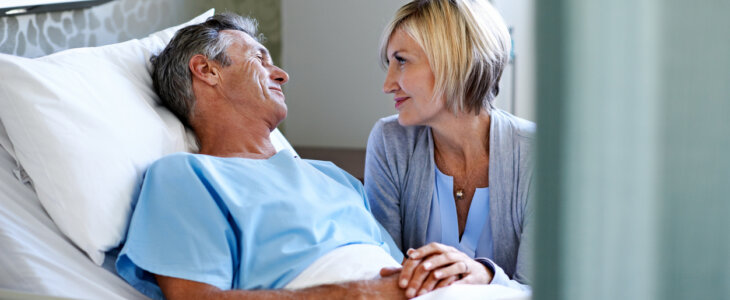 Shot of a wife comforting her husband lying in a hospital bed