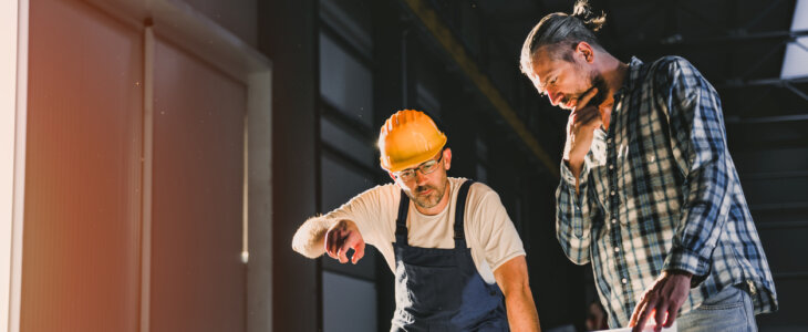 Construction workers checking checking blue print